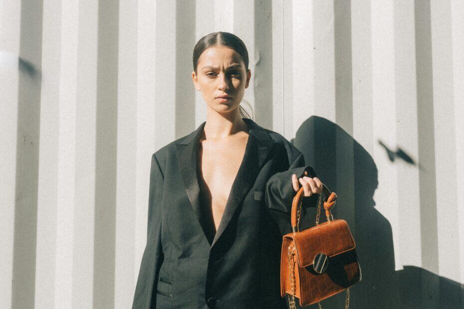 Begleiterin packt die braue Tasche einer Escort Dame mit Essentials für ihr Date.