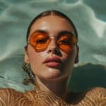 Sonniges Leben als Sugarbabe. Symbilisiert durch eine schöne Frau mit Sonnenbrille im Wasser eines Pools liegend.