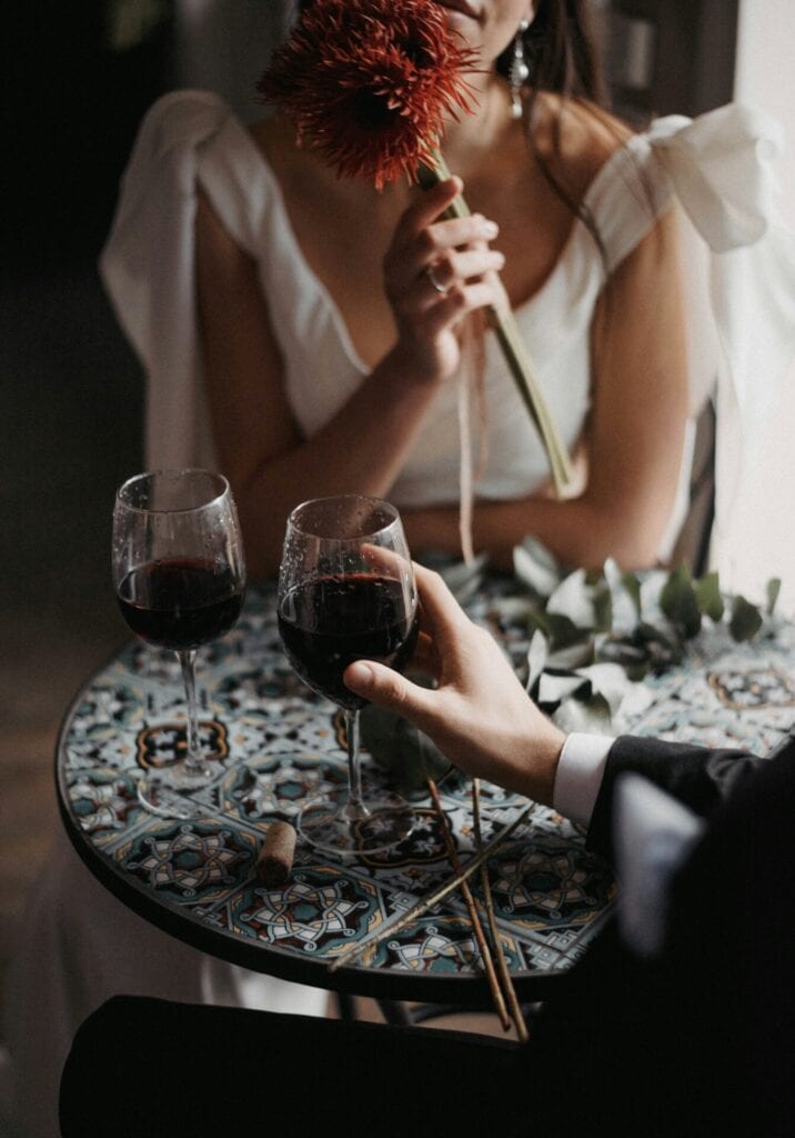 Date mit einem Glas Rotwein als Symbolbild für Dates über Escort Agenturen