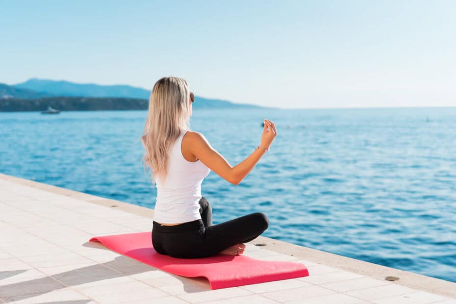 Coverbild zum Artikel Yoga für Escort Damen mit einer Frau auf Yogamatte am Meer.